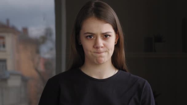 Young brunette caucasian girl unsatisfied upset woman standing indoor posing looking at camera showing dislike putting thumb down expressing disagreement refusal negative attitude denying no symbol — Stock Video