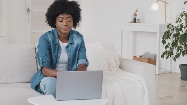Стрессовая молодая афроамериканка испытывает головную боль мигрень или напряжение глаз, работая на ноутбуке дома, расстроенная женщина страдает от боли негативное влияние современных технологий здравоохранения, переутомление — стоковое видео