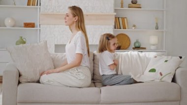 Aile kavgası Kafkasyalı öfkeli genç anne ve küçük anaokulu kızı koltukta oturup birbirlerini görmezden geliyorlar üzüntü kırgınlığı yanlış anlama çatışması yaşıyorlar.