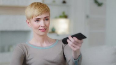 Kadın hafta sonunu evde tek başına, uzaktan kumandalı kanallar tutarak geçirir. Kaygısız hisseder, rahat bir koltukta rahatça dinlenir. Oturma odasında televizyon programlarında reality şov programları izleyip eğlenir.