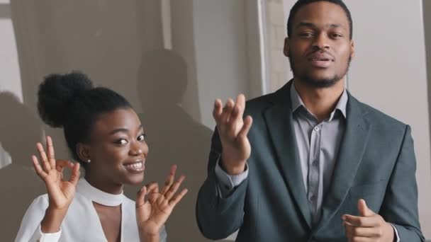 Удивлена, что афроамериканские студенты-интерны или коллеги улыбаются, глядя в камеру, показывая жест. Успех смешанного расового бизнеса и деловой женщины — стоковое видео