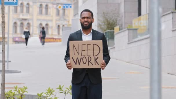 Deprimido desesperado afroamericano millennial empresario mostrando cartel necesitan trabajo. Infeliz mixta oficina trabajador negro desempleo joven adulto estudiante de pie al aire libre sosteniendo cartel de cartón — Vídeos de Stock