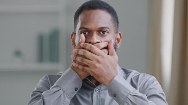 African American bearded black male millennial businessman lawyer or student crime witness closing covers his mouth with hands refusing to tell terrible secret, promises keep mystery silence, closeup — Stock Video