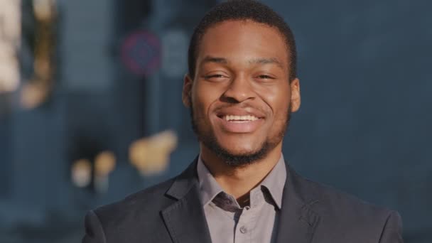 Happy African American empresário treinador empregado gerente estagiário olhando para a câmera, jovem misto raça masculino trabalhador de escritório estagiário profissional com rosto feliz posando sozinho ao ar livre close-up retrato — Vídeo de Stock