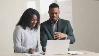 İş görüşmelerinde dizüstü bilgisayarda birlikte çalışarak online projeyi tartışan bilgisayar işkadını ve işadamını kullanan mutlu ve çeşitli genç iş arkadaşları.
