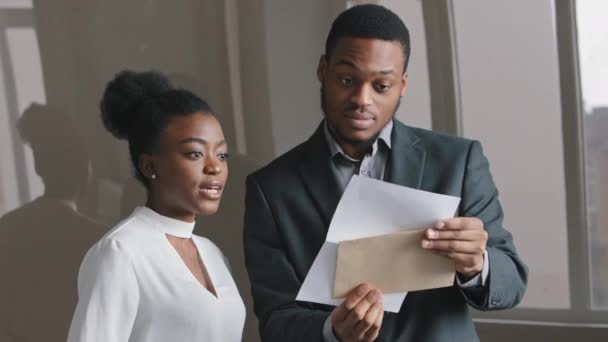 Happy young African businessman and businesswoman holding papers sprawdzić statystyki sprzedaży patrząc na raport finansowy świętować sukces biznesowy, czuje się zmotywowany przez wielkie osiągnięcia dobry wynik pracy — Wideo stockowe