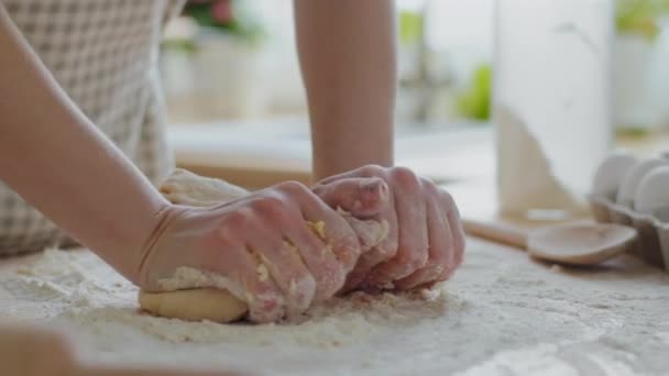 Közelkép női kéz gyúrni tészta az asztalon segítségével búzaliszt készíti kenyérsütés otthon a modern konyhában, felismerhetetlen kaukázusi nő fiatal háziasszony szakács pék főzés pékség kávézó pizzéria — Stock videók