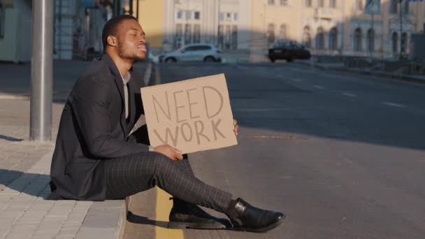 A raça mista desesperada depressiva perturbada demitiu o empregado corporativo masculino sentado em etapas fora do escritório. Jovem adulto empresário foi falido, perdeu negócios senta-se ao ar livre com mesa de papelão Precisa de trabalho — Vídeo de Stock