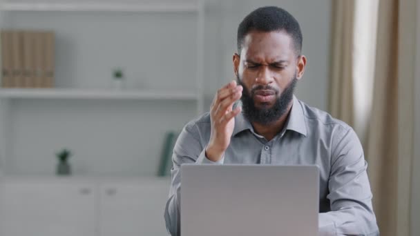Przygnębiony afrykański biznesmen sfrustrowany czytaniem złych wiadomości czuje się zdenerwowany mając problem, czuje się zdesperowany porażką biznesową siedząc przy biurku. Student dostał e-mail z nieudanymi wynikami egzaminu — Wideo stockowe