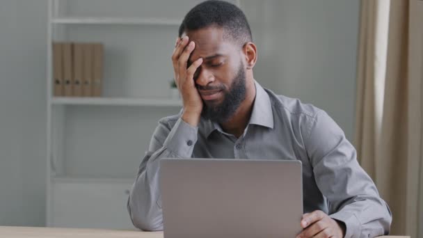 Ansioso estressado cansado jovem Africano americano empregado gerente ou estudante negro sentado com laptop cai adormecido cara oprimido trabalhando no computador em casa moderna escritório, conceito de fadiga crônica — Vídeo de Stock