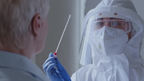 Orvos orvos nővér nő visel egyéni védőfelszerelés légzőkészülék maszk csinál coronavirus tampon női idős beteg, Covid-19 pcr teszt beteg fertőző idős, felismerhetetlen hölgy