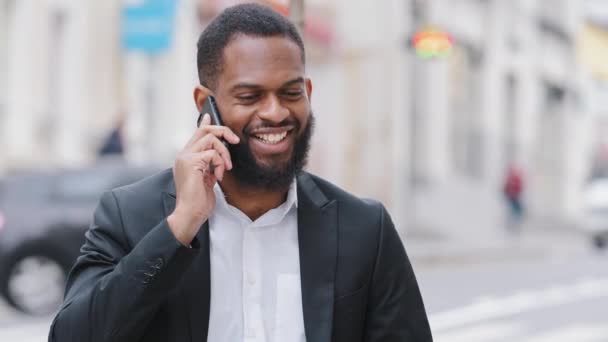 Close-up glimlachende duizendjarige bebaarde Afro-Amerikaanse ondernemer praten met de klant via de telefoon, nuttige informatie delen, orde op afstand met behulp van moderne draadloze technologie, mobiele verbinding concept — Stockvideo