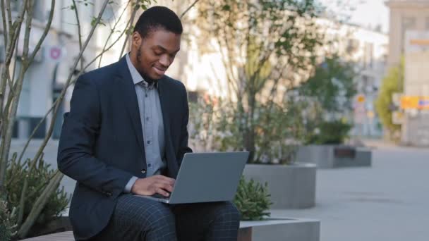 Enfocado Hombre africano americano empresario estudiante de negocios escribiendo en el curso en línea de estudio de PC con el ordenador portátil, serio joven mestizo étnico tipo que trabaja profesional a distancia utilizando software informático — Vídeos de Stock