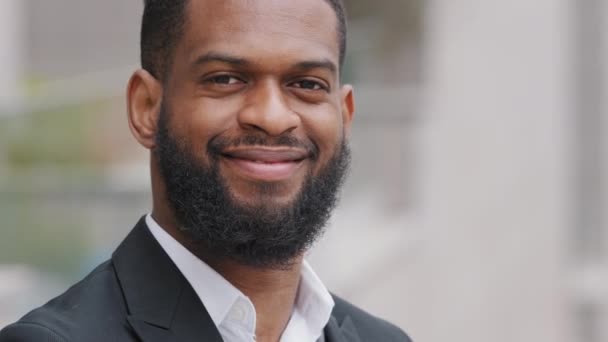 Een close-up portret van een vrolijke zwarte man met een baard in pak. Jonge volwassen succesvolle mannelijke zakenman ondernemer of zelfverzekerde duizendjarige student het verhogen van de hand tonen ok gebaar — Stockvideo
