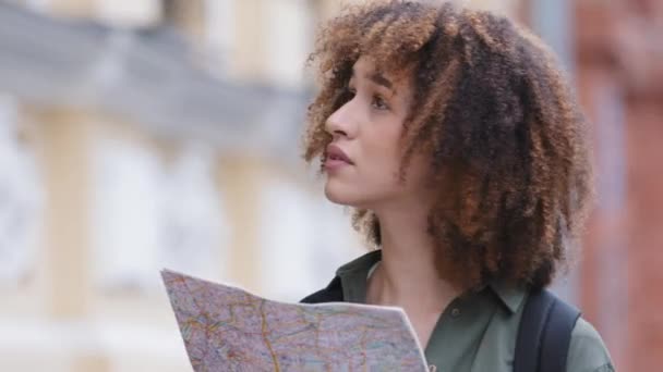 Zmatený zoufalý mladý kudrnatý černošky studentka zkoumání papírové mapy města se snaží najít cestu. Millennial smíšené rasy ženské turistické ztracené v cizí zemi, kteří hledají stavbu, potřebují pomoc — Stock video