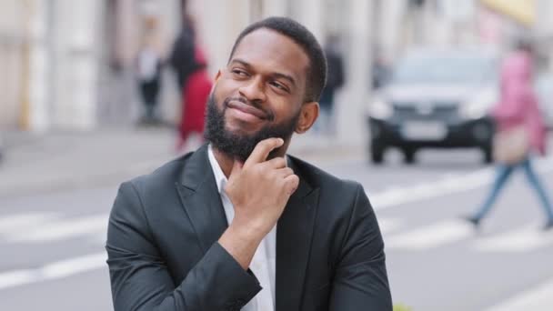 Een close-upportret van een jonge man met een baard die buiten staat. Gemengd ras student of zakenman kijkt weg na te denken over de toekomst, kiest de beste opties, analyseert, dromen. Herinneringen nostalgie in nieuwe stad — Stockvideo