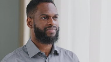Gülümseyen sakallı, binlerce yıllık Afrikalı adam kameraya bakıyor. Kendine güveni olan yakışıklı, zeki, genç, yetişkin girişimci, lider, yönetici pozu veren. Yakın plan yüz görünümü iş portresi
