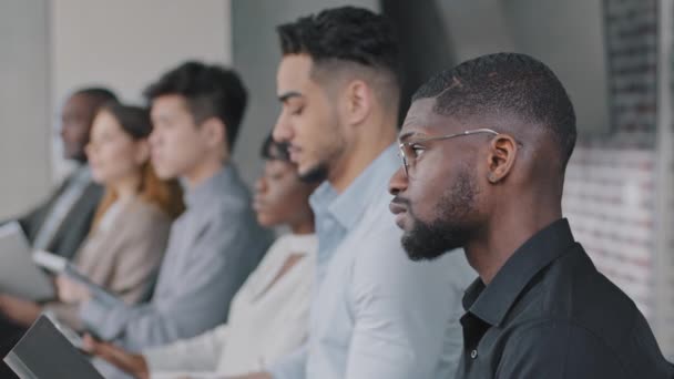 Multiracial business team corporate employees group multiethnic colleagues women and men sitting in office meeting training learning listening writing information notes in notebooks, side view — Stock video