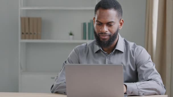 Unavený úředník afrického amerického dělníka sedí za stolem s laptopem usíná cítí nemotivovaný vyčerpaný učinit rozhodnutí spát místo práce. Přepracovaný muž, neproduktivní zaměstnanecký koncept — Stock video