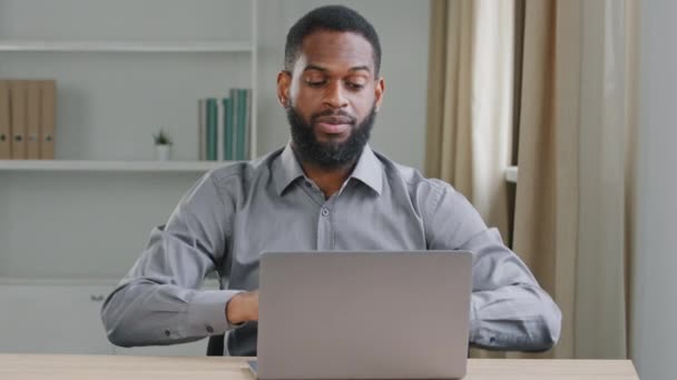 Jovem trabalhador de escritório fazendo horas extras realizando tarefas urgentes preparando relatório digitando no laptop, fazendo uma pausa curta, pausa. Africano americano moderno escritor jornalista prepara artigo escreve romance — Vídeo de Stock