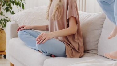 Çekilen görüntülerde genç beyaz anne nilüfer pozisyonunda oturuyor. Kanepede meditasyon yapıyor. Stres atmaktan zevk alıyor.