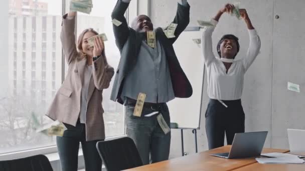 Úspěšné nadnárodní obchodní tým mnohonárodnostní kolegové pracovníci Afričan muž šéf a afro manažer běloška v úřadu házení peněz v dešti dolarů bankovky získat zisk investice — Stock video