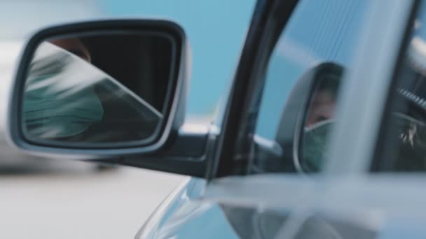 Detailní odraz v zrcadle africký americký mladý krásný dívka afro žena řidič nosí lékařskou ochrannou masku obličeje snižuje skleněné okno v autě sedí v autě cítí nedostatek čerstvého vzduchu v automobilu — Stock video