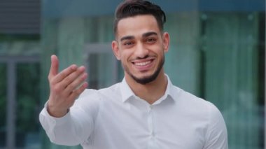 Portre dostu gülümseyen, dişlek İspanyol iş adamı İspanyol patron beyaz resmi tişört giyer. Davetiye göstererek yaklaşın, dışarı çıkın, vücut dilleri işaretini kullanın.