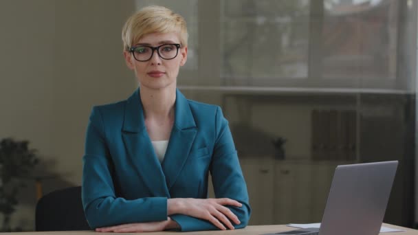 Portré komoly sikeres professzionális érett nő rövid haj üzletasszony női szaktitkár visel zöld kabát és szemüveg ül az asztalnál az irodában laptop nézi a kamerát — Stock videók
