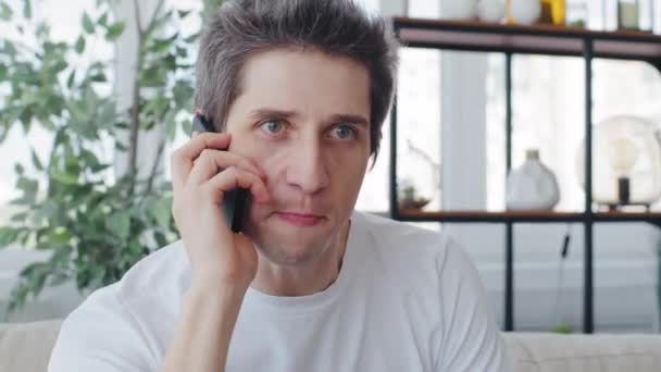Портрет розлюченого кавказького чоловіка в білій футболці розчарований божевільним емоційним чоловіком, який розмовляє по телефону криками, висловлює незадоволення відповіддю на виклик сварки концепції конфлікту — стокове відео