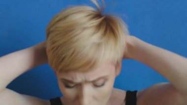 Beyaz kadın portresi, orta yaşlı, sarışın, kaslı, kısa saçlı, spor salonunda yerde yatan, yoga kardiyo egzersizi yapan kadın portresi.