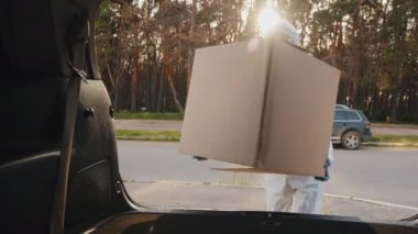 Kadın doktor hemşire, tıp işçisi kurye tüketicisi koruyucu maske takıyor ve Coronavirus 'un gözlüklerini takıyor. Bagajında siparişler olan büyük karton kutuları salgın sırasında teslim ediyor.