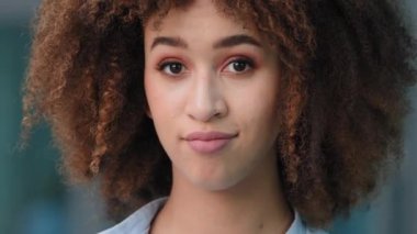 Olağanüstü yakın plan bir portre. Açık havada güzel Afro-Amerikan kadın etnik ırk afro kız. Makyajlı kız öğrenci, kamera önünde el sallıyor.