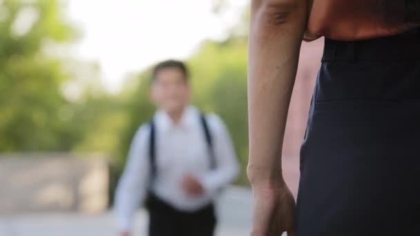 Unfocused flou enfant fils garçon élève écolier en uniforme scolaire cours à mère aimante courir à femme brune méconnaissable après la classe rencontre parent maman câlins cou embrasser, réunion de famille — Video