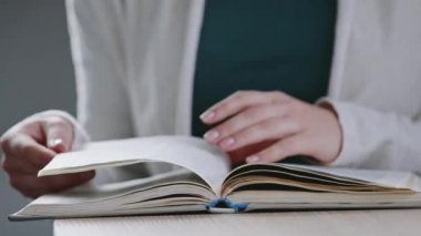 Tanımlanamayan beyaz kadın öğrencinin kadın ellerini kapat. Sözlük kitabının sayfalarını çevir. Edebiyat oku.