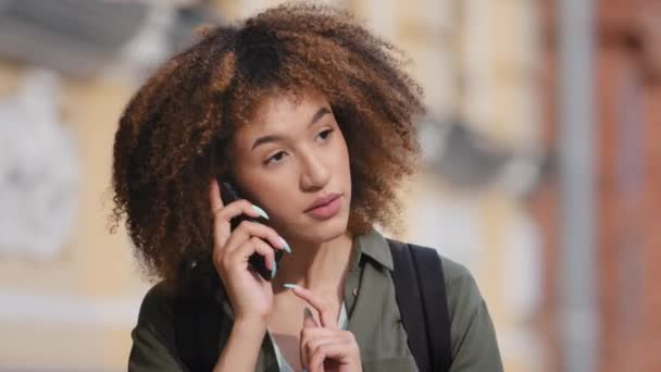 Zdenerwowana młoda Afrykanka patrząca na ekran telefonu, sfrustrowana, negatywnie nastawiona do okropnego sygnału. Nieszczęśliwy tysiącletniego użytkownika kobieta niezadowolony ze złej pracy urządzenia elektronicznego — Wideo stockowe