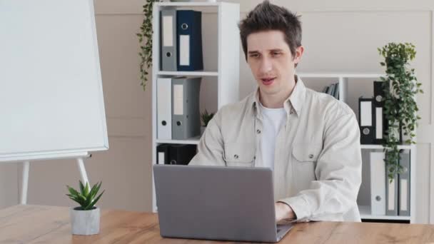 Тисячолітній бізнесмен хлопець позаштатний дизайнер користувача, який працює в офісі, сидячи за столом з ноутбуком типізації робить помилку низькоакумуляторних комп'ютерних проблем з розбитим мережевим додатком паніки помилок — стокове відео