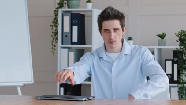 Funny comic caucasian freelancer business man doing mechanical movements with hands pretending to be robot takes laptop puts on office desk typing on keyboard points palm at computer looking at camera — Stock Video