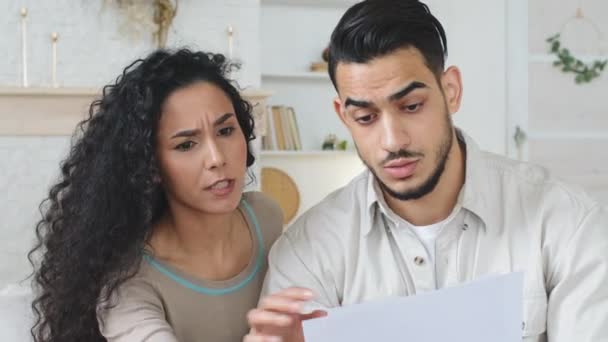 Det latinamerikanska paret sitter hemma på soffan och får skilsmässopapper brev med dåliga nyheter, arg irriterad man och kvinna skriker om räkningar lån orolig för problem med finansiella kostnader — Stockvideo