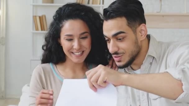 Coup de projectile recadré couple espagnol hispanique barbu beau jeune homme et frisée femme d'épagneul recevoir lettre enveloppe ouverte lire avis de banque bonnes nouvelles se réjouir sentir bonheur étreinte plaisir faire geste de victoire — Video