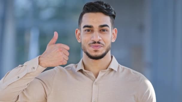 Male portrait happy satisfied enthusiastic smiling toothy hispanic man businessman looking at camera shows like puts thumb up supports approves recommends dental center service makes excellent gesture — Stock Video