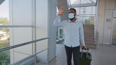 Tıbbi maskeli Afrikalı Amerikalı işadamı yeni ülkeye havaalanı terminaline geldi. İspanyol yönetici ortağıyla tanıştı. İş gezisi sırasında dirsek tokuşturdu.