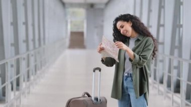 Beyaz, bayan, bayan, bayan yolcu, bavullu turist, havaalanı terminalindeki tren istasyonuna bakıyor.