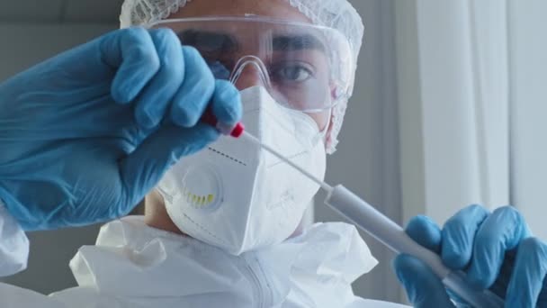 Visão em primeira pessoa médico cientista trabalhador de laboratório em máscara uniforme de proteção médica e óculos leva amostra de saliva para teste de PCR coloca mão segurando cotonete na direção da câmera análise vívida — Vídeo de Stock