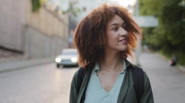 Genç çekici melez siyah milenyum kızı Afro saçlı ve sırt çantalı yol boyunca tek başına yürüyor. Yabancı bir şehirde seyahat eden Afrikalı kadın turist. Bağımsız yolculuk, seyahat kavramı