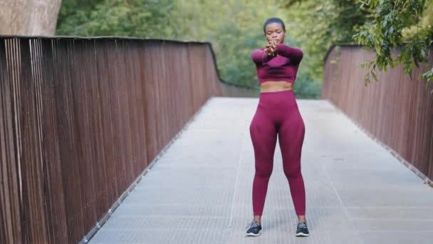 晨练健身的年轻黑人千禧年女子在公园。田径混合赛女子准备每天跑步，做伸展运动的胳膊，肩膀。健康的生活方式，瘦身的概念 — 图库视频影像