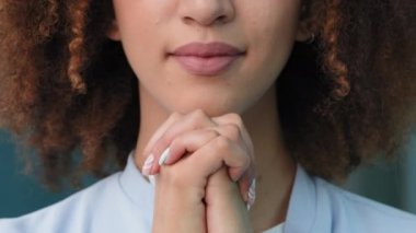 İnsan vücudunun yakın planda çekilmiş bir parçası. Kadın eli umutla dua ediyor. Tanınmaz genç kız kıvırcık saçlı Afro-Amerikan kadın avuç içleri katlayıp dua ediyor. Tanrı 'ya dua ediyor.