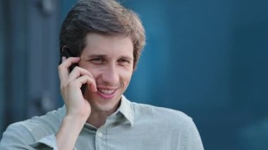 Telefonla konuşuyorum. Kendine güvenen, serbest çalışan bir erkek, kulağına cep telefonu dayayıp müşteriye profesyonel danışmanlık yapıyor. Genç adam arkadaşlarıyla iş konuşur ya da hizmet malları siparişi verir.