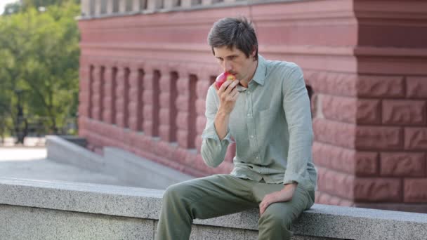 Caucasian guy scared by disappearance olfactory, smells nothing. Young man holding sniffing fruit, surprised discovers smell absence, sniffs apple, checks, can not believe coronavirus symptoms concept — Stock Video