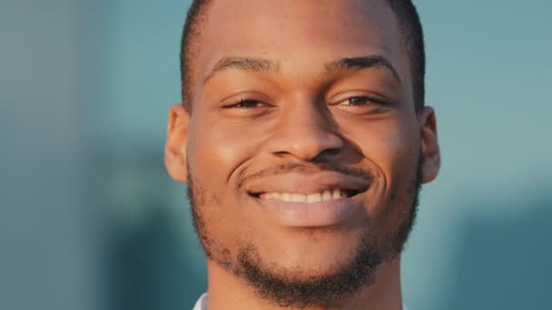 Männliches Porträt im Freien Nahaufnahme afroamerikanischer Mann schwarzafrikanischer Typ lächelnd zahmes Gesicht glücklich Kopf Client Geschäftsmann stehend posiert im Freien Blick in die Kamera mit freundlich zufriedenem Ausdruck — Stockvideo
